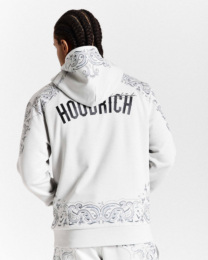 Person wearing a white hoodie with intricate patterns and 'Hoodrich' branding on the back.