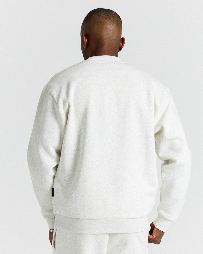 Person wearing a white tracksuit against a light gray background