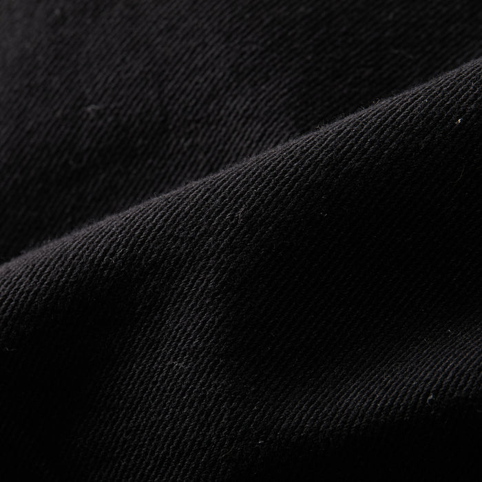 Close-up of the Men's Sequoia Jacket in Shadow Black, showing a diagonal weave and soft folds that highlight the texture and detail of its cotton twill fabric.