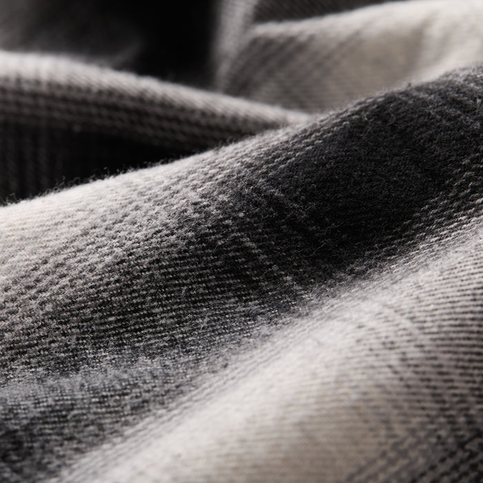 Close-up of the soft, black and white plaid fabric from the Men's Sequoia Jacket- Shadow Black, highlighting its fine flannel lining texture and gentle material folds.
