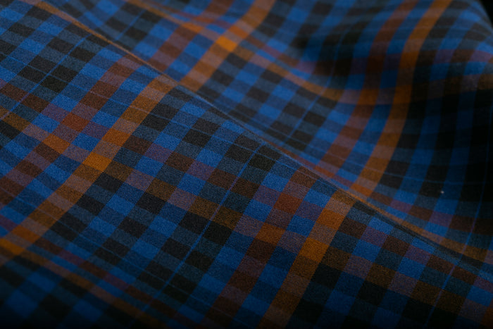 Close-up of Pladra Men's Short Sleeve Tailwinds Shirt in Lagoon Blue, showcasing a blue, black, and brown plaid pattern.