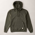 The Men's Sierra Hoodie in Pine Green is a premium heavyweight French terry cotton hoodie with a front pocket, drawstring hood, ribbed cuffs and hem, and a small white tag on the pocket corner. Shown flat on a light background.