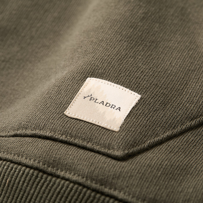 Close-up of the Men's Sierra Hoodie- Pine Green, a premium cotton hoodie with olive green knit fabric, featuring a small white rectangular patch with the PLADRA brand name and a tree graphic above the text.