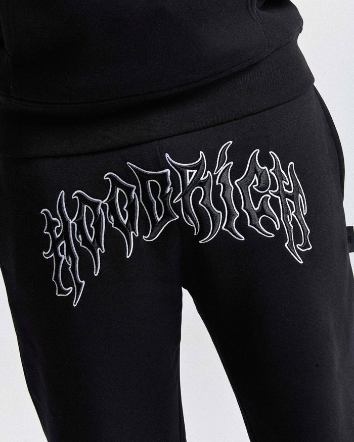 Black sweatpants with white embroidered text on a light gray background