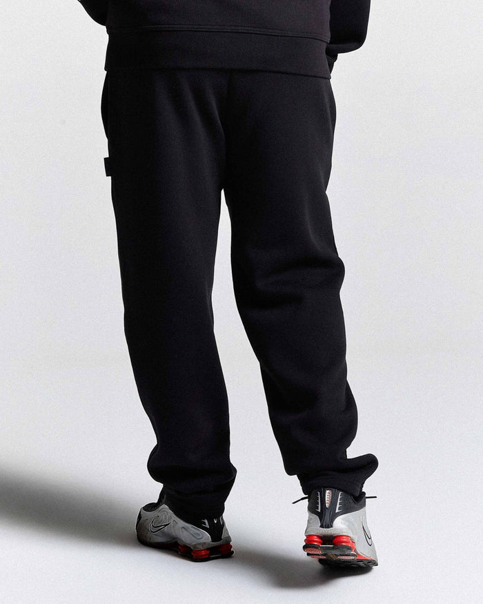 Person wearing black pants and shoes on a white background