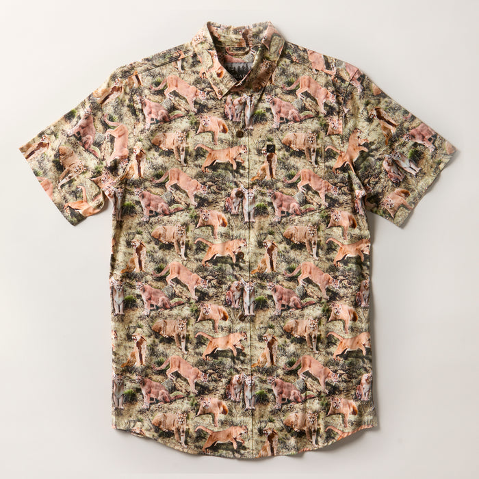 Men's S/S Printed Outdoor Aloha Shirt in Mountain Lions, a cotton short-sleeve button-up with an all-over print of mountain lions, giraffes, cheetahs, and zebras.