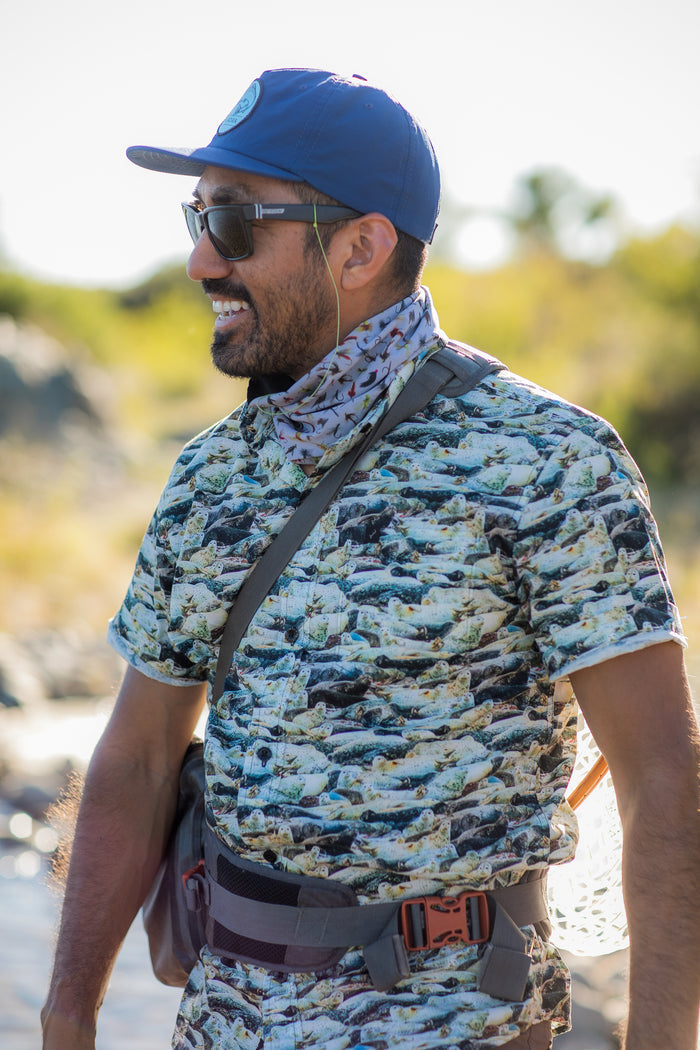 Smiling man in sunglasses and blue cap wears Pladra Men's S/S Printed Outdoor Aloha Shirt - Seals, 100% cotton.