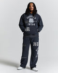 Person wearing a dark gray hoodie and pants with branding on a light gray background
