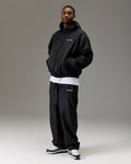 Displays a model wearing the Black 'Hoodrich' branded Men's The Winner's Circle Ripstop Woven Full Tracksuit
