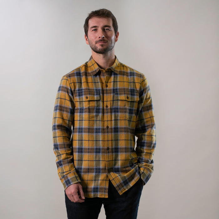 Man with short hair and beard wears a Pladra Men's Workhorse Elite Flannel Shirt in Easton Gold against a plain background.
