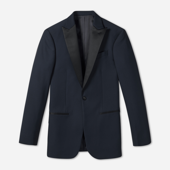 Midnight blue tuxedo jacket laid flat, black satin peak lapels and single button, front view