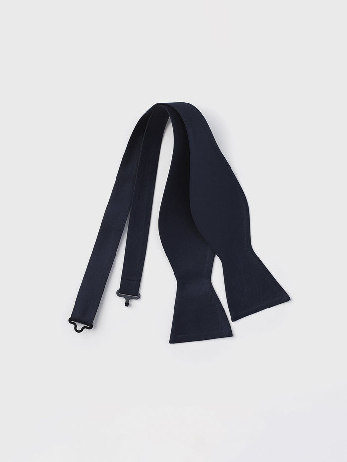 Midnight self-tie butterfly bow tie, untied, laid flat on light grey background