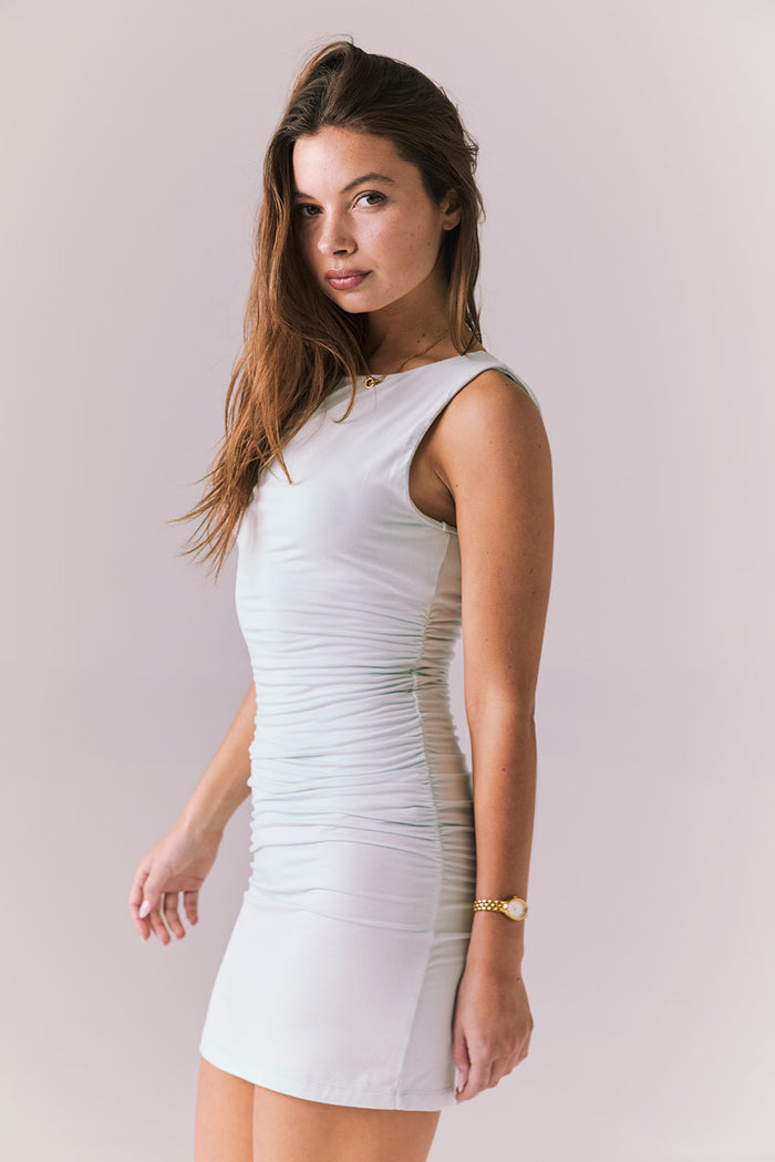 Three quarter angle of Chaser Brand Mila Ballad Blue Mini Dress showing flattering curve-hugging silhouette and smooth finish