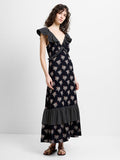 Woman wearing a floral and spot black printed midi dress with ruffle sleeves and a deep V neckline