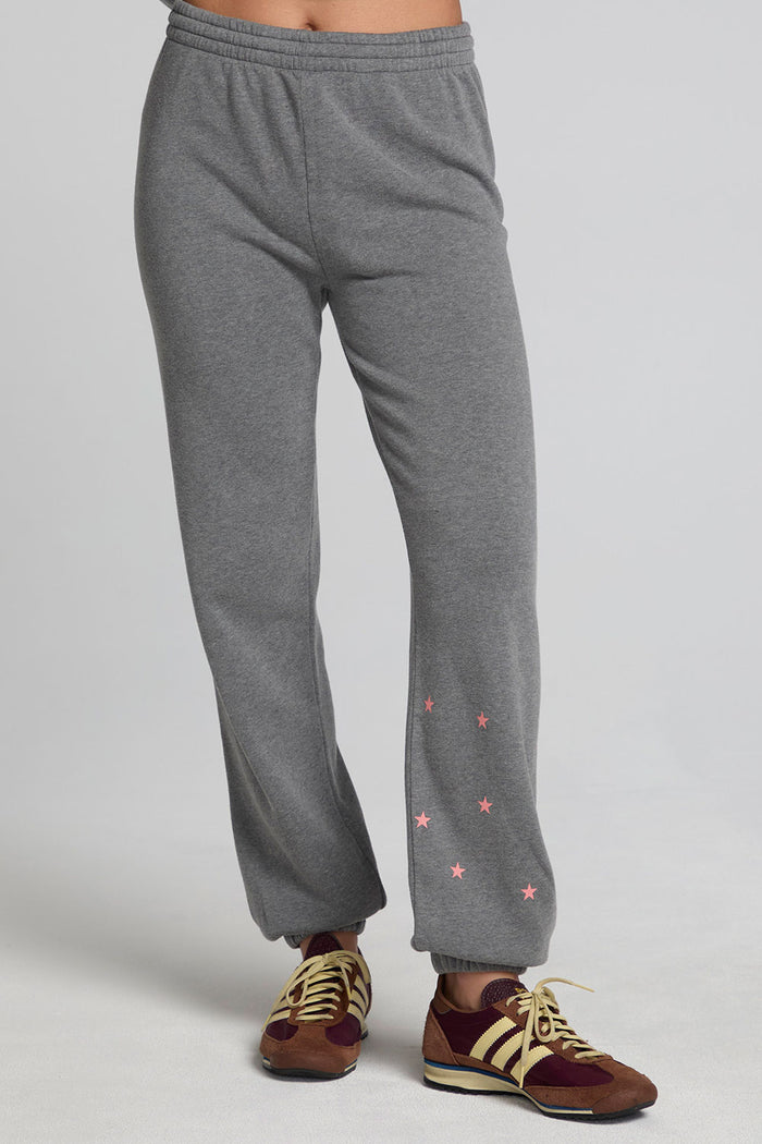 Front view of a woman wearing the Chaser Mini Star Glaze Pants and matching sweatshirt on a neutral background
