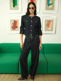 A woman wearing high waisted, dark blue jeans with a fly zip, belt loops and a curved fit.
