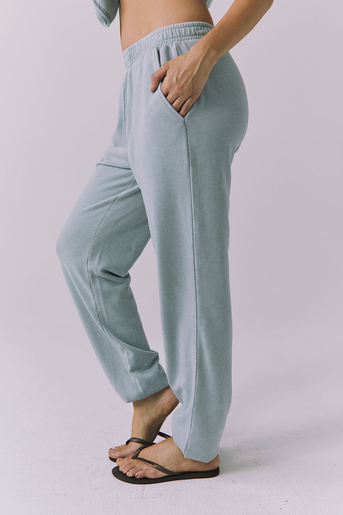 Side view of woman wearing Chaser's Mission Joggers in garden green sage on a plain background