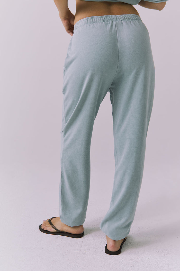 Back view of woman wearing Chaser's Mission Joggers in garden green sage on a plain background