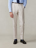 Close-up of man in mojave tan linen pleated pants, light blue shirt, navy tie, front view