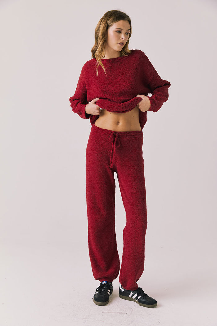 Full body view of woman wearing Chaser’s Monica Purple-Red Fig Joggers with matching Miller Purple-Red Fig Pullover Sweater on a white background