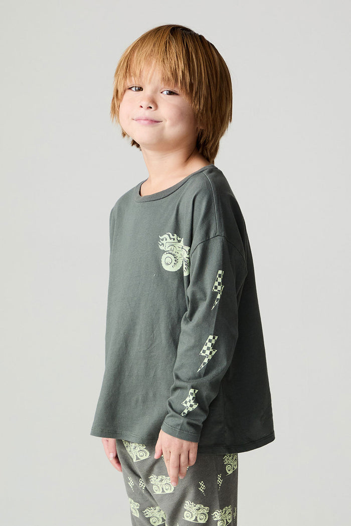 Side angle view of a boy wearing the Chaser Monster Truck Boys Tee on a neutral background with matching pants