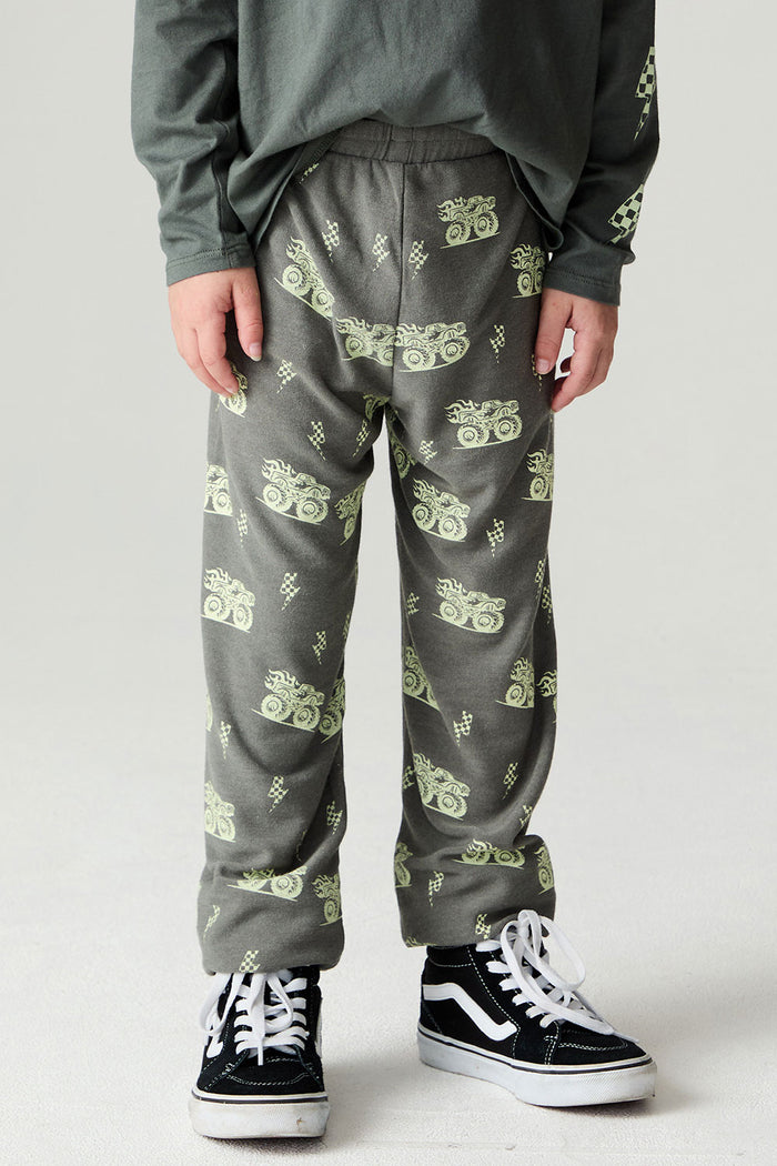 Front view of a boy wearing the Chaser Monster Truck Pants Boys Joggers on a neutral background with long sleeve top