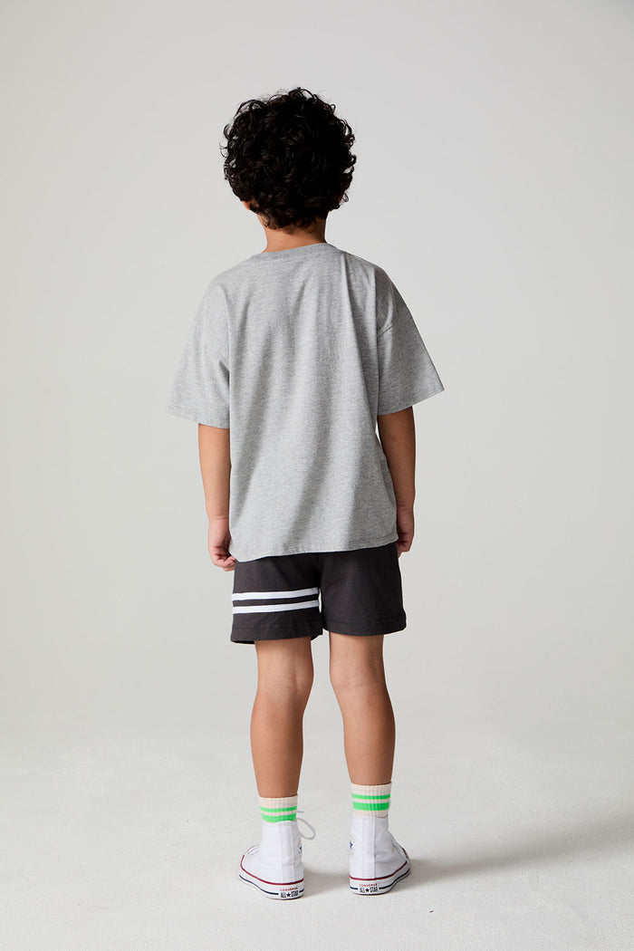Full body back view of a boy wearing the Chaser  Moto LA Tee on a neutral background