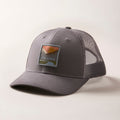 Mountain Trucker Hat in Charcoal Grey, a mid-crown grey mesh cap with a mountain landscape patch and adjustable snap back.