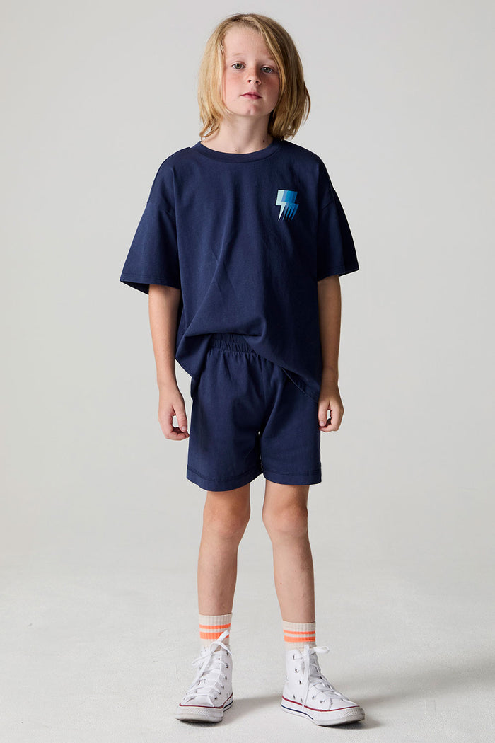 Full body front view of a boy wearing the Chaser Multi Bolt Shorts on a neutral background
