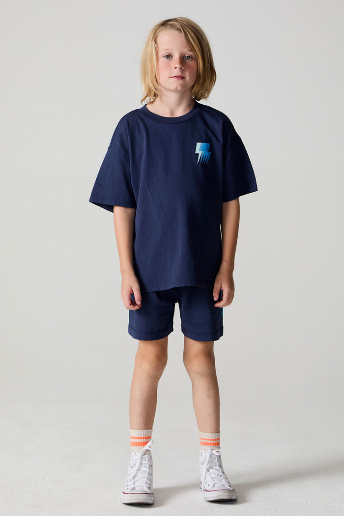 Full body front view of a boy wearing the Chaser Multi Bolt Tee on a neutral background