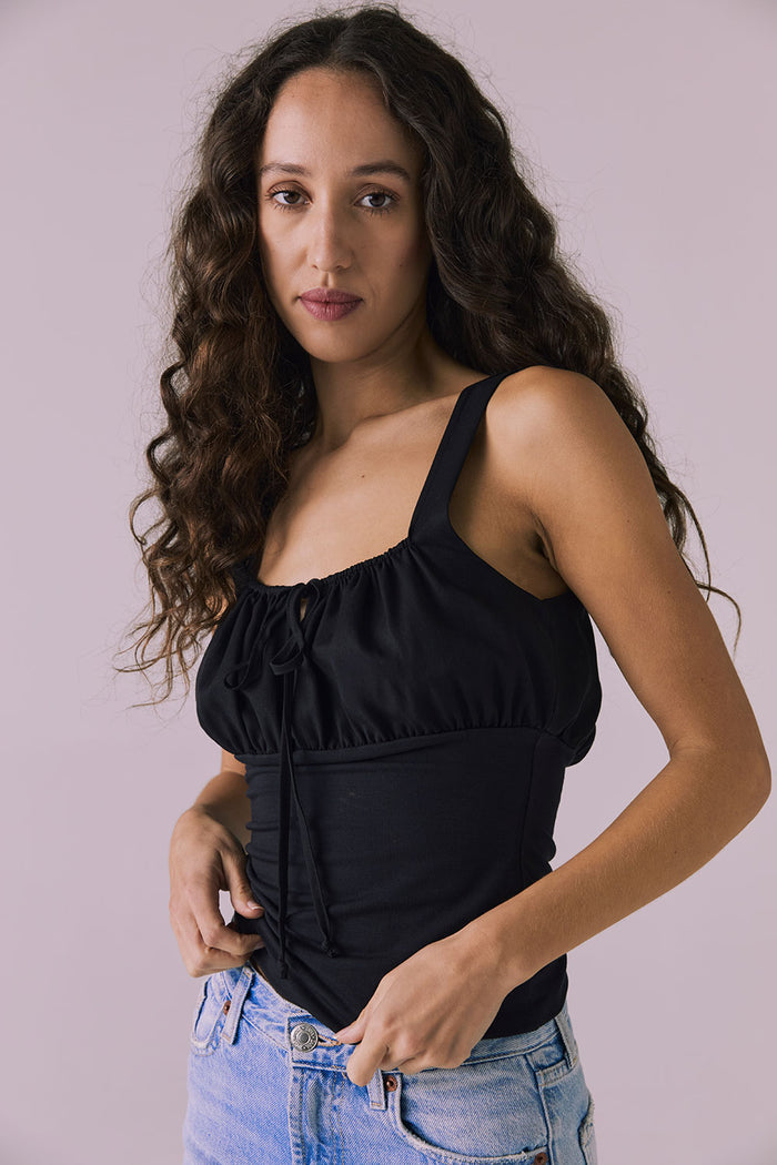 Angled side view of the Chaser Nancy Tank in Black emphasizing the clean lines and contoured waist