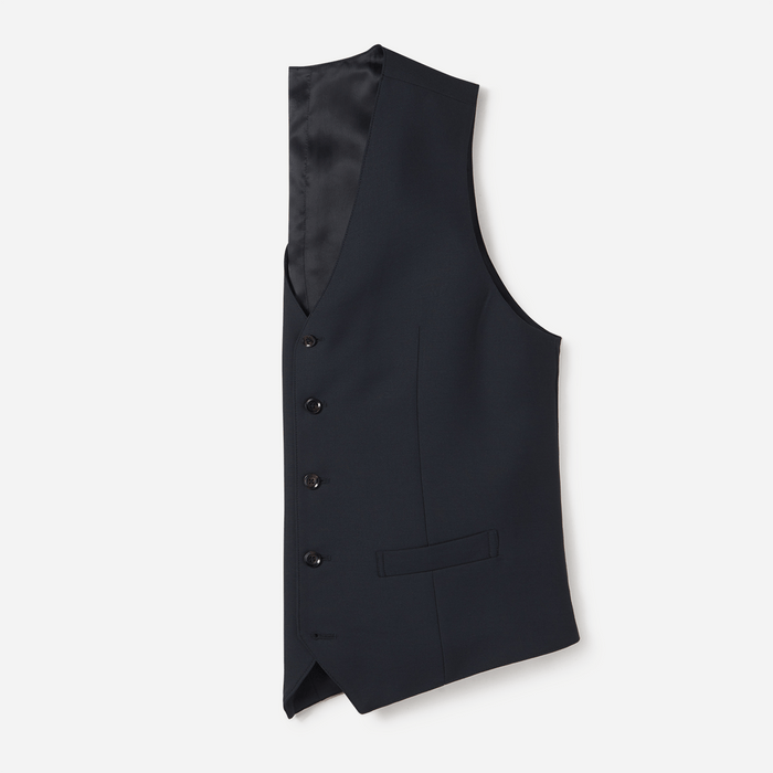 Navy blue suit vest laid flat, satin back panel and welt pocket visible, side angle