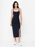 A woman wearing a ribbed midi-length dress with strips, a square neckline, a white contrast trim and split hem.