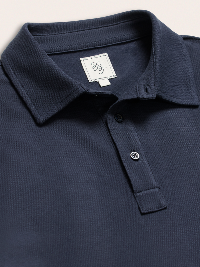 Close-up of navy cotton pique polo shirt collar and two-button placket