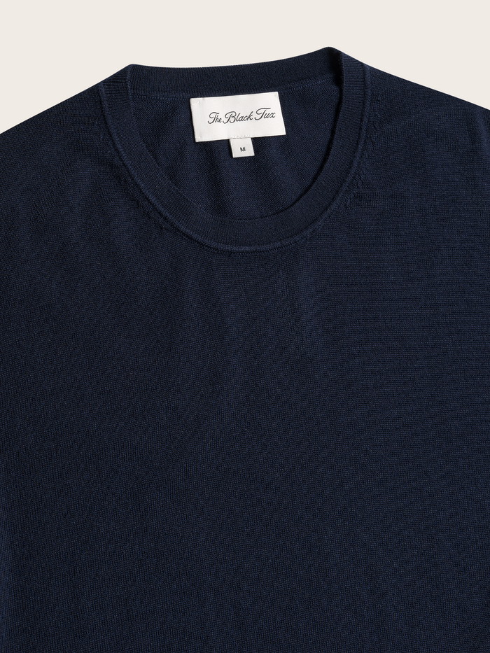 Close-up of navy crewneck sweater collar and brand label