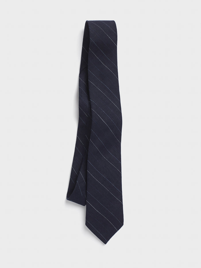 Navy pinstripe linen necktie hanging against a light grey background