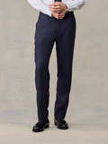 Close-up of man in navy plaid wool suit pants with hands clasped, front view
