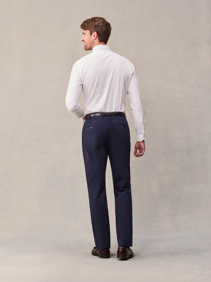 Back view of man in white shirt and navy seersucker pants, full length