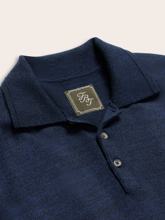 Close-up of navy sweater polo collar and three-button placket with brand label