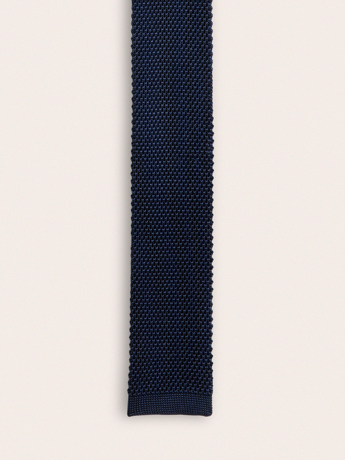 Navy silk knit tie laid flat, showing textured knit weave