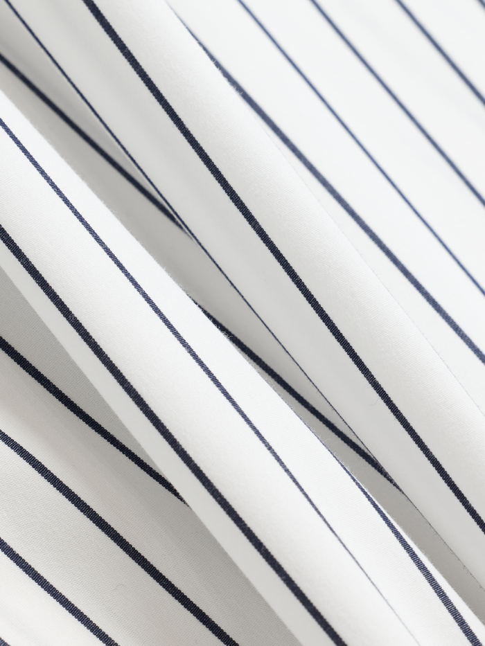 Close-up of white and navy striped dress shirt fabric with folds