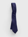 Navy wool-silk necktie draped vertically against a light grey background