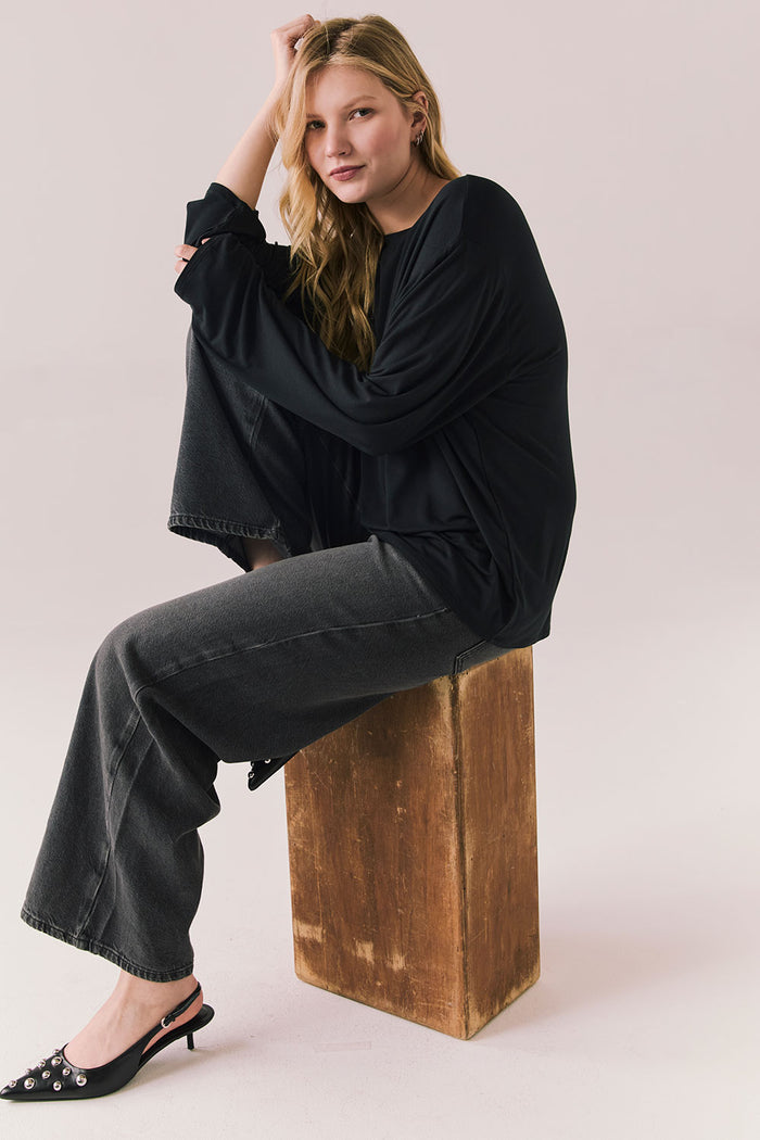 Oversized black long sleeve top with dropped shoulders and relaxed silhouette.