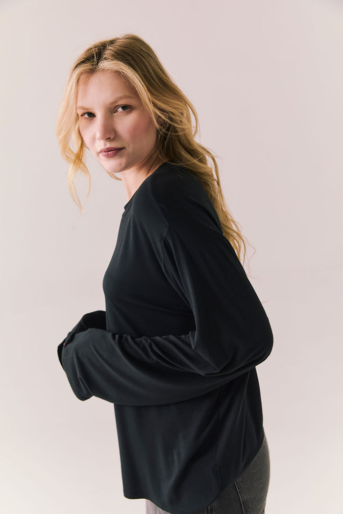 Oversized black long sleeve top with dropped shoulders and relaxed silhouette.