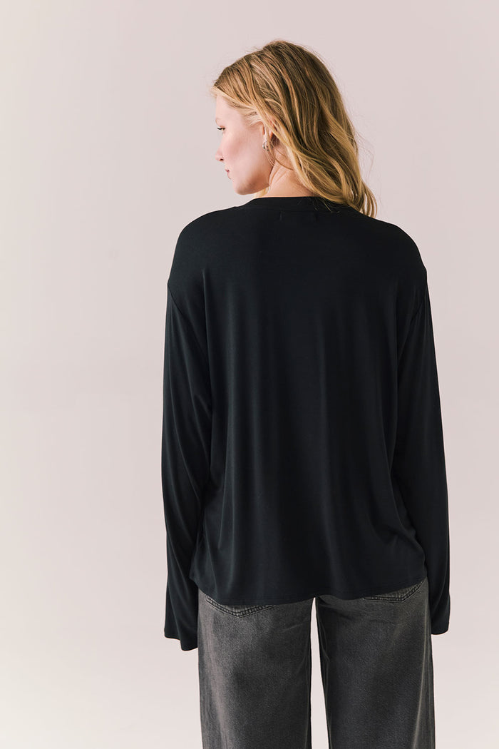 Oversized black long sleeve top with dropped shoulders and relaxed silhouette.