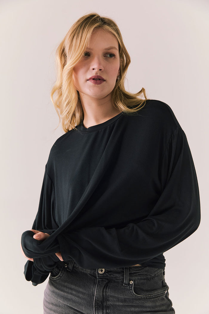 Oversized black long sleeve top with dropped shoulders and relaxed silhouette.