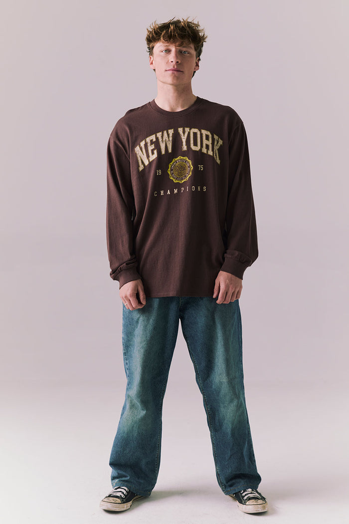 Full body of model in Kahlua Brown New York 1975 long sleeve tee.