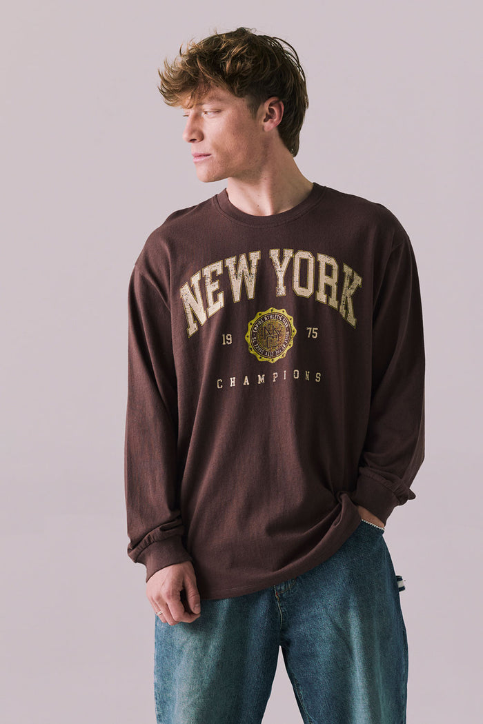 Front view of New York 1975 long sleeve tee in Kahlua Brown with cityscape graphic.