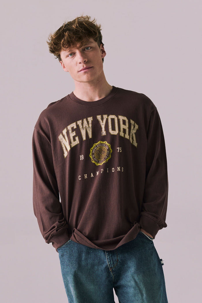 Front view of New York 1975 long sleeve tee in Kahlua Brown with cityscape graphic.