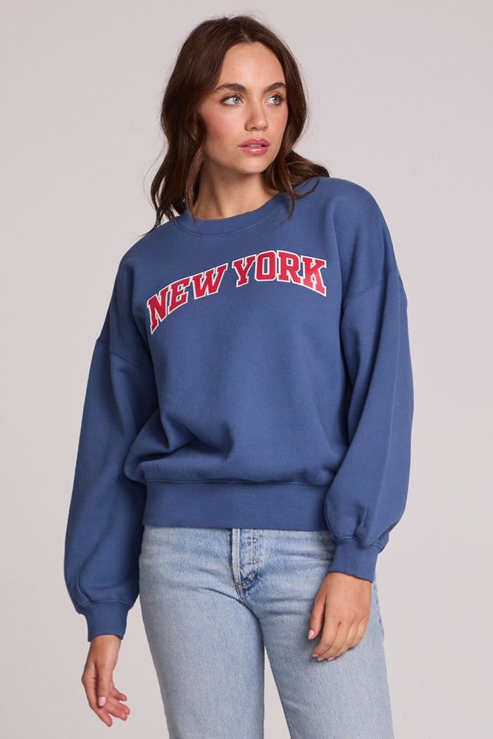 Front view of a woman wearing the Chaser New York Tee on a neutral background